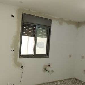 חוטי חשמל יוצאים מהקיר בחדר בבנייה