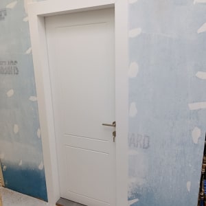 דלת לבנה מותקנת בקיר כחול