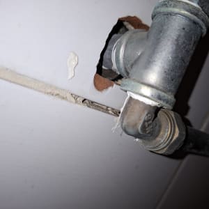 צינור מתכת עם חור בקיר