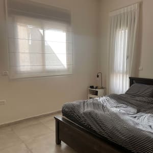 וילון רומאי וחלון עם וילון לבן בחדר שינה