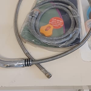 צינור מים גמיש עם אריזה על משטח עבודה במטבח