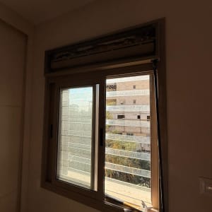 חלון עם תריסים וכלי עבודה לידו