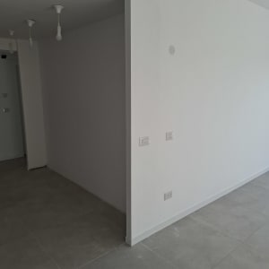 קיר גבס לבן עם שקעי חשמל ותאורה תלויה