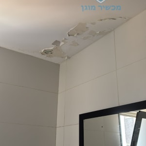 תקרה מתקלפת עם קיר אריחים וחלון פתוח