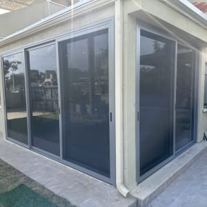 סגירת מרפסת באלומיניום עם ויטרינות זכוכית ורשתות הזזה