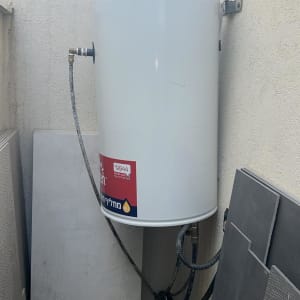 דוד שמש מותקן על קיר חיצוני עם צינורות מחוברים