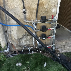 צנרת ומד מים ליד קיר חיצוני