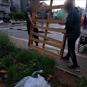 שני אנשים נושאים מסגרת עץ ברחוב