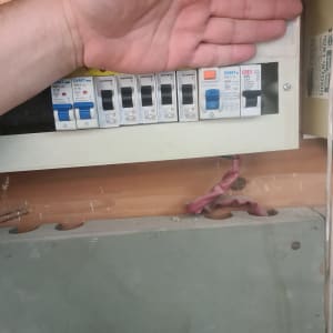 לוח חשמל עם מפסקים שונים ויד אדם