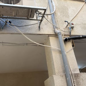 יחידה חיצונית של מזגן מותקנת על קיר חיצוני של מבנה
