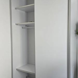 ארון לבן עם דלתות הזזה ומדפים פנימיים