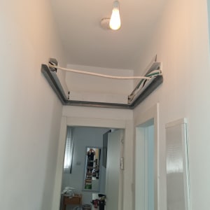 תיקון תקרה עם חוטים וכלים בחדר צר