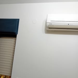 קיר לבן עם מזגן וחלון כחול