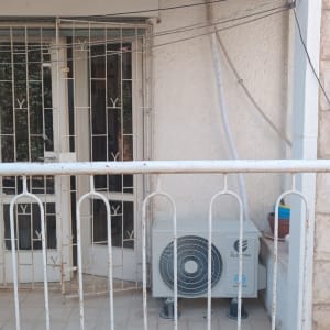 יחידת מזגן מותקנת על מרפסת עם סורגים