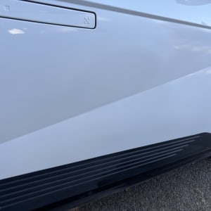 חלק צדדי של רכב לבן עם דלת וסף שחור