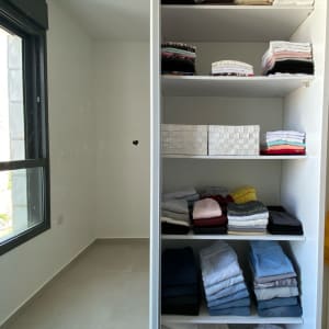 ארון בגדים עם מדפים מסודרים בבגדים מקופלים