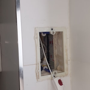 פתח בקיר עם צינורות וכלי עבודה