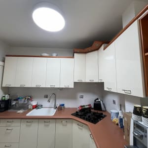 מטבח עם ארונות לבנים, כיור וכיריים גז