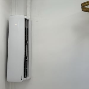 מזגן קיר לבן מותקן על קיר לבן