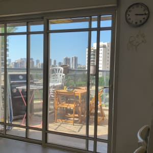 מרפסת עם שולחן וכיסאות דרך דלת זכוכית