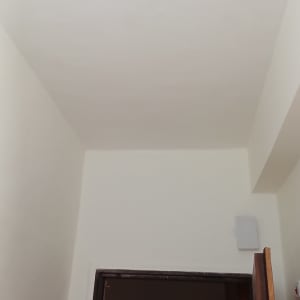 קיר ותקרה צבועים בלבן עם דלת פתוחה