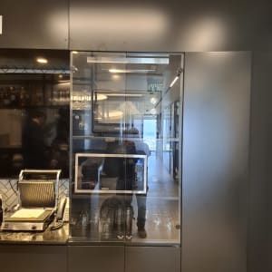 ארון זכוכית עם כוסות ומיקרוגל במטבח מודרני