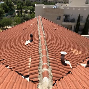 גג רעפים אדום עם צינורות ואיטום בטון