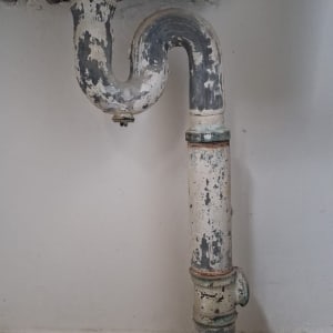 צינור מתכת ישן עם חלודה מתחת לכיור