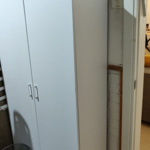 ארון לבן עם מזוודה וכלי כתיבה עליו