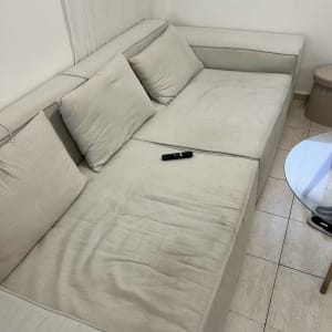 ספה בהירה עם כריות ושלט על המושב