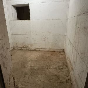 חדר ריק עם קירות בטון וחלון קטן