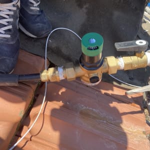 שסתום פליז עם ידית שחורה וצינור מחובר