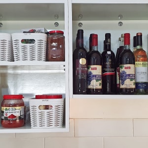 ארון מטבח עם בקבוקי יין וסלסלות אחסון