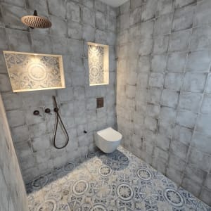 מקלחת עם אריחים מעוצבים, ראש טוש ומדף מובנה