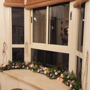 קישוט פרחים צבעוניים על אדן חלון