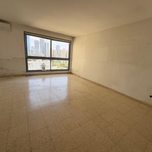 חדר ריק עם חלון גדול ונוף עירוני
