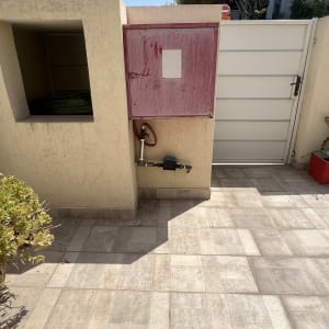 ארון מים עם צינור ליד שער לבן