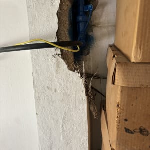 צינור כחול בקיר עם חוטים חשמליים