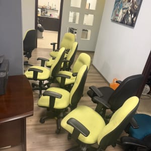 חדר עם כיסאות משרדיים ירוקים ושולחן עץ