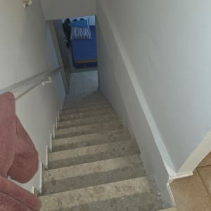 מדרגות עם מעקה וחדר עם מיטה בסוף