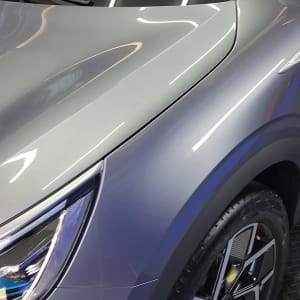 מכונית אפורה עם פנס קדמי וגלגל מעוצב