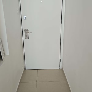 דלת לבנה עם ידית כסופה על רצפת אריחים
