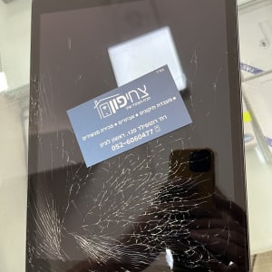 מסך אייפד שבור עם כרטיס ביקור מונח עליו