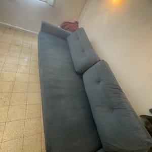 ספה כחולה בחדר עם רצפת אריחים