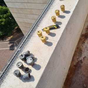 חלקי מתכת וכלים על מעקה בטון