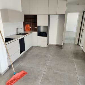 רצפה נקייה עם מגב כתום במטבח מודרני