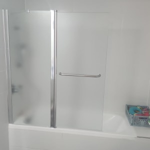 מקלחון עם דלת זכוכית ומגבת תלויה