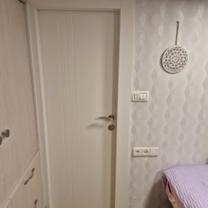 דלת לבנה עם ידית מתכת בחדר פנימי