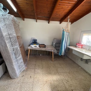 חדר עם רהיטים מכוסים בניילון, שולחן וכיור