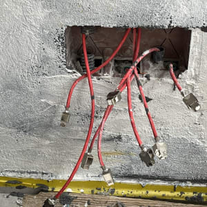 כבלים אדומים עם מחברים בקיר פתוח